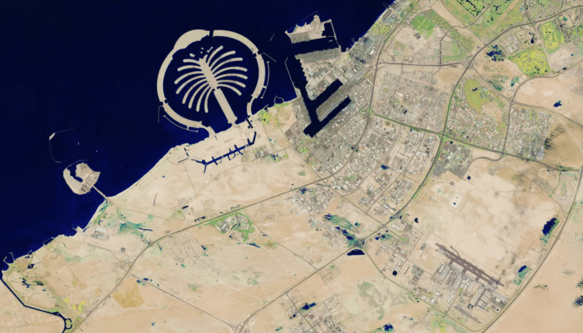 Satellite view of Dubai with the Palm Jumeirah and main road network visible — the toll system covers most of the central road grid